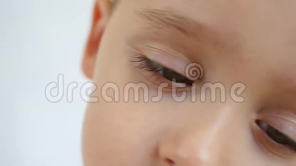 儿童在白色背景下慢动作特写的脸和眼睛视频的预览图