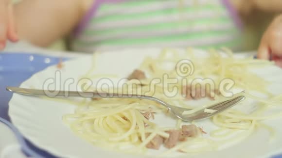 可爱的小女孩用叉子吃肉意大利面视频的预览图