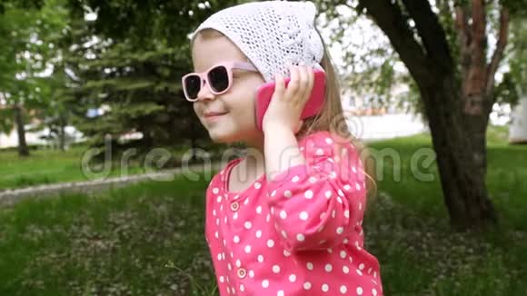 小女孩在公园里用儿童电话说话视频的预览图