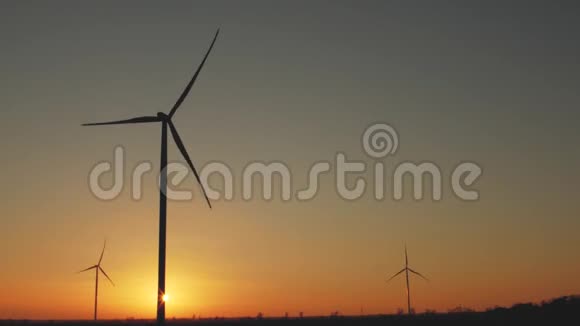 日落时分的风力发电厂工作中的风力发电机视频的预览图