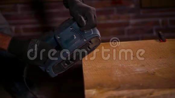 在工人手中用磨床抛光木边的侧面视图视频的预览图