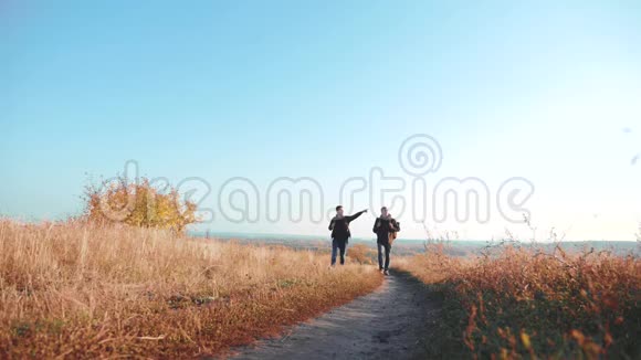 两个男子徒步旅行者带着背包徒步旅行沿着这条小径爬山慢动作视频的预览图