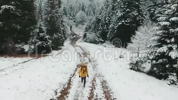 空中射击冬天一个背着背包的人正在上山从白雪皑皑的小路上看着视频的预览图