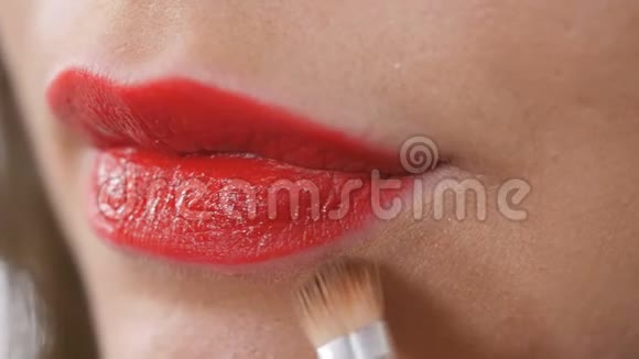 美容师用红色唇膏修正女性嘴唇的化妆品视频的预览图