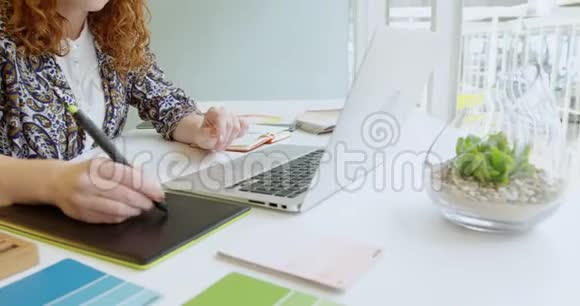 女商人使用图形平板电脑和4k笔记本电脑视频的预览图