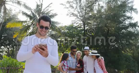 人类在热带棕榈树公园与青少年群体在线使用手机聊天视频的预览图