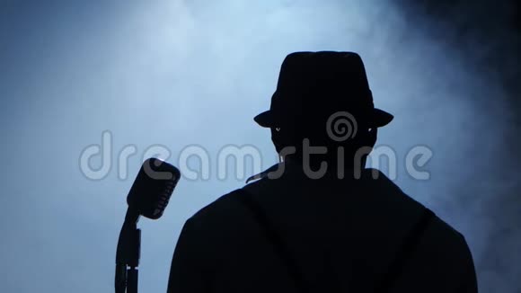 歌手一半的营业额在烟雾和白光中拿着他的麦克风和手势的手唱歌黑色视频的预览图