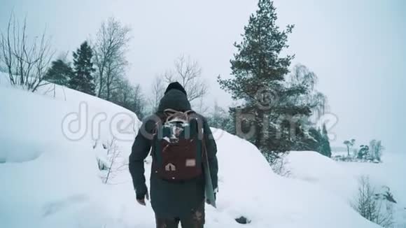 冬天的一天年轻人走在雪覆盖的小径上湖岸上视频的预览图