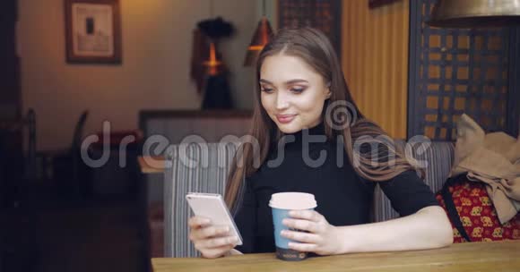 有咖啡和智能手机的女孩视频的预览图