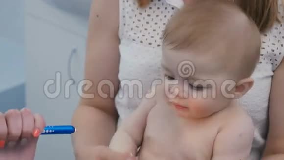 医生把手电筒照进婴儿的嘴里视频的预览图