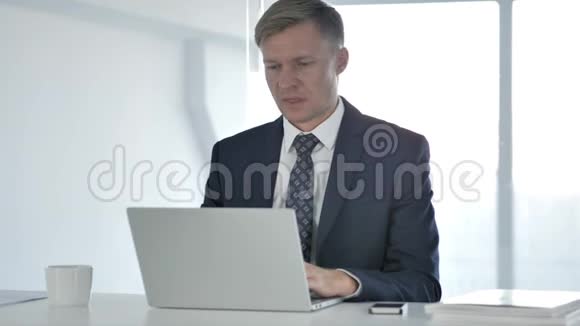 商人在笔记本电脑上工作时打哈欠视频的预览图