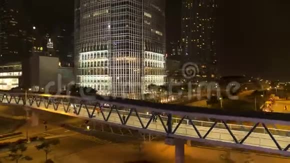 行人天桥与路人在道路上方的夜间城市背景库存行人天桥夜间步行视频的预览图