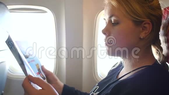女人在飞机上靠窗看日记视频的预览图