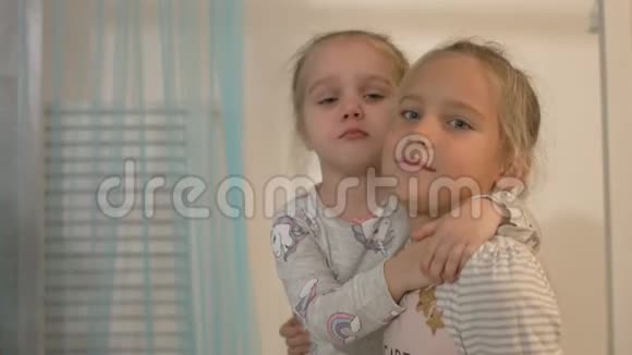 两个小女孩在家里微笑拥抱视频的预览图