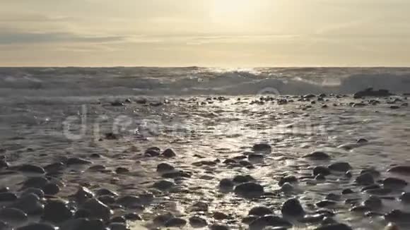 在海边的石滩上太阳路径在海面上视频的预览图