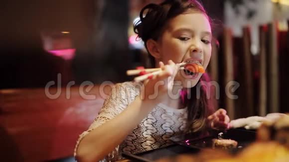 日本餐馆的小女孩尝试寿司卷筷子视频的预览图