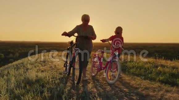 奶奶和她的孙女一起散步他们边走边骑自行车健康的生活方式和积极的态度视频的预览图