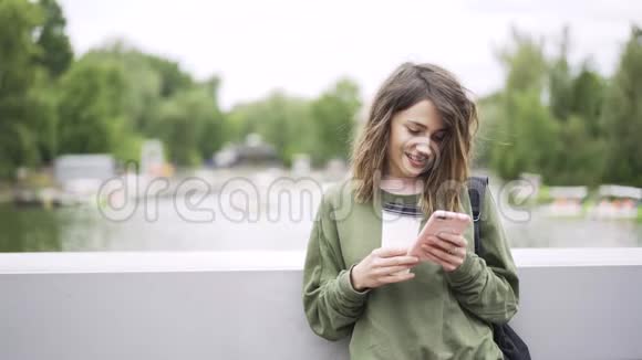 年轻女商人在桥上听音乐喝咖啡视频的预览图