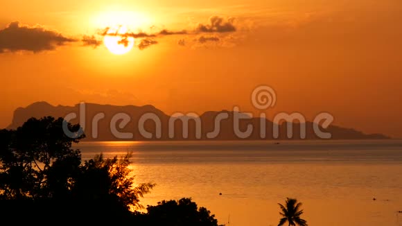 雄伟的热带橙色夏季实时日落海面上有群山的轮廓戏剧性黄昏的空中景色视频的预览图