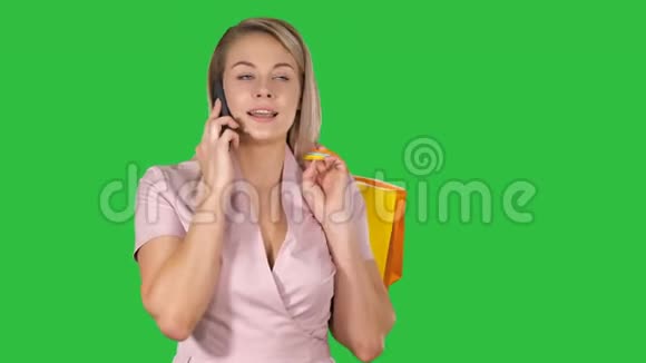 年轻女子带着购物袋在手机上对着绿色屏幕说话发色钥匙视频的预览图