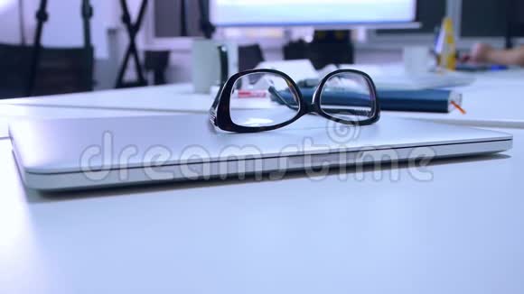 眼镜放在办公桌上的笔记本电脑上特写视频的预览图