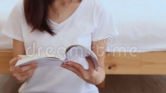 在家的卧室里美丽的亚洲女人可以放松地坐着看书视频的预览图