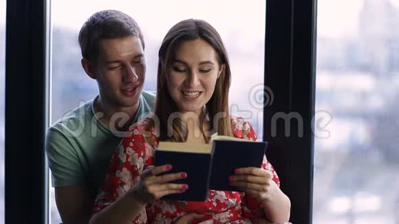 一对可爱的年轻夫妇在家一起看书视频的预览图
