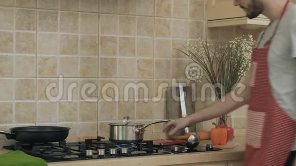 一个人在炉子上做饭的时候试着洗碗视频的预览图