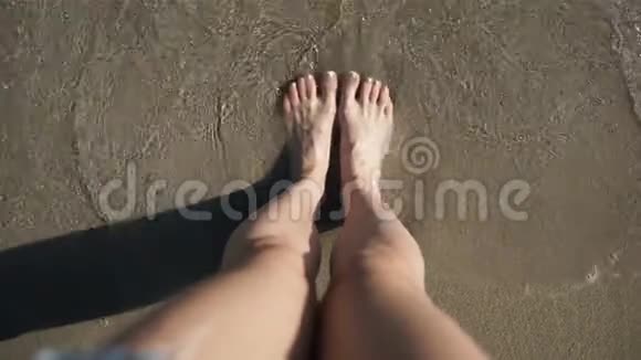 海浪冲刷着女人沙滩上的脚视频的预览图