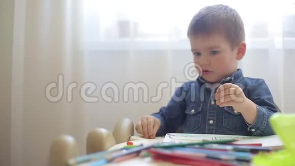 小男孩不想学画画用铅笔转动桌子视频的预览图
