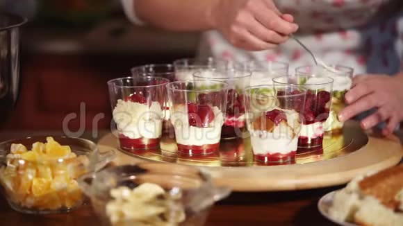 糕点厨师正在用奶油切水果和其他甜食来填充甜点杯视频的预览图