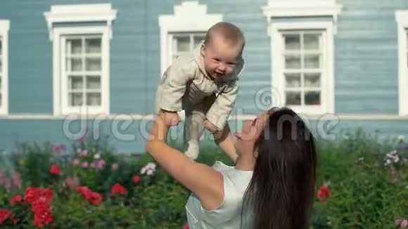 嬉戏的母亲把快乐的女儿抱在花园里视频的预览图