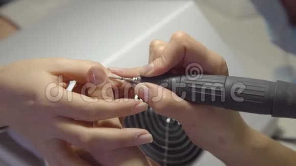 美容院的指甲师傅为一位年轻女子修指甲清洁和抛光视频的预览图