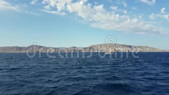 船在群山的映衬下在波涛汹涌的海面上航行以海岸和海滩为背景的黑海视频的预览图