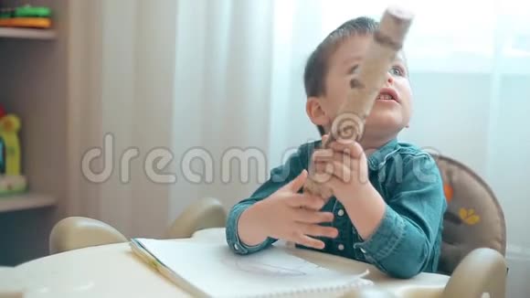 小男孩把一支很大的铅笔扔在地上视频的预览图