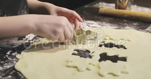 小厨师漂亮的手在饼干面团上切出形状视频的预览图