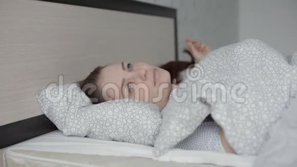 睡眼的年轻女性醒来后伸展身体视频的预览图