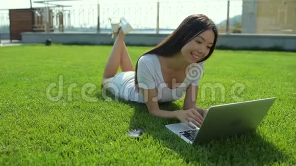 在大自然背景下使用笔记本电脑的漂亮亚洲女孩视频的预览图