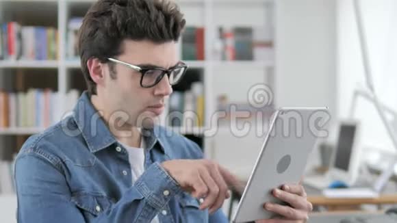 有创意的人在平板电脑上浏览互联网视频的预览图