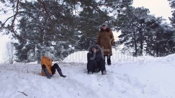 爸爸和女儿在冬天滑雪狗在雪地里玩耍幸福的家庭在公园里和狗放松视频的预览图