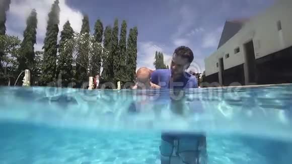 快乐微笑的蹒跚学步的孩子和爸爸在水下潜水视频的预览图