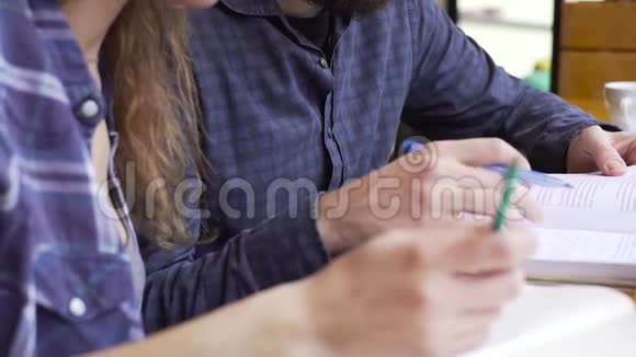 男青年在咖啡馆帮助女孩备考视频的预览图