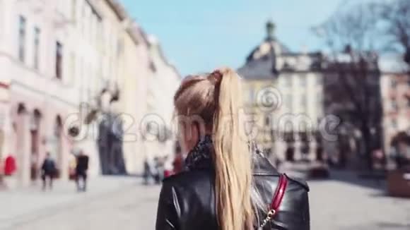 快乐的年轻女子穿着优雅的衣服在利沃夫散步s中转向镜头微笑快乐阳光灿烂的一天视频的预览图