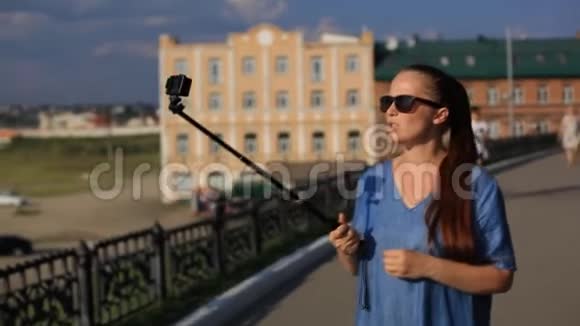 女性博客在社交网络上为他的博客拍摄动作相机上的视频视频的预览图