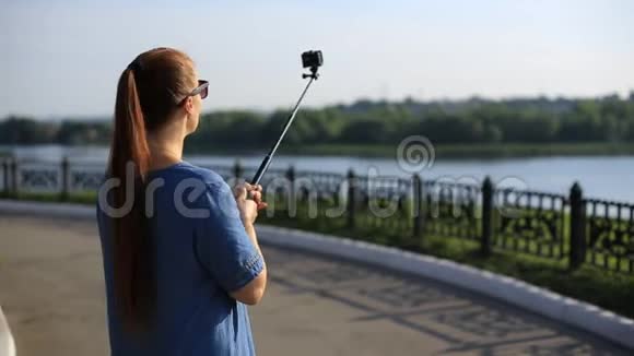 女性博客在社交网络上为他的博客拍摄动作相机上的视频视频的预览图