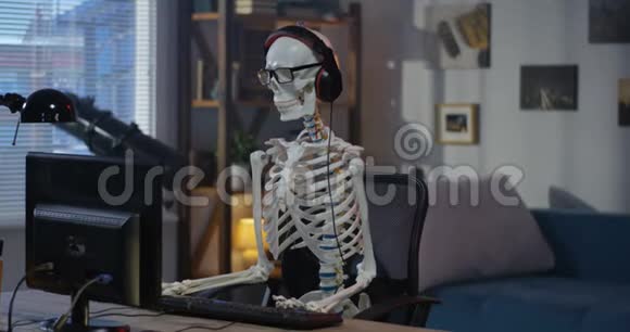 戴着耳机的骨架坐在电脑前视频的预览图
