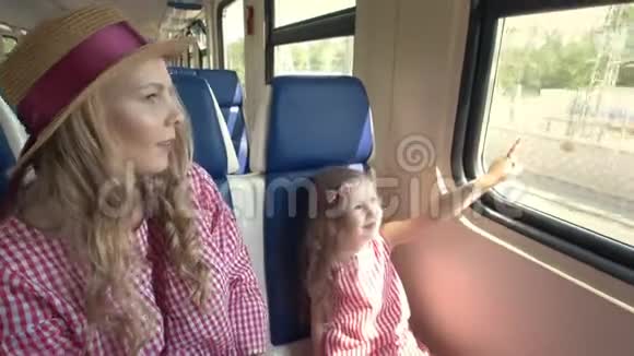 快乐的妈妈和女儿一起旅行上火车看看窗外视频的预览图