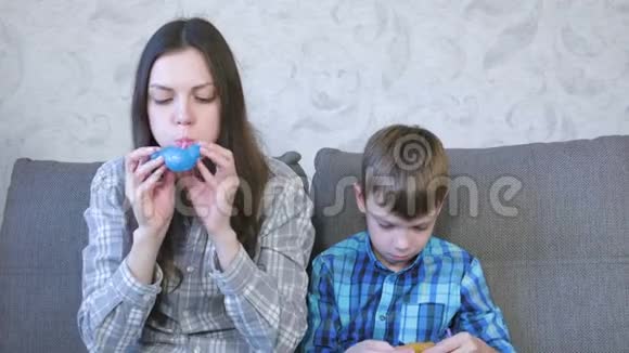 妈妈和儿子从粘泥中膨胀一个大泡泡玩黏液视频的预览图