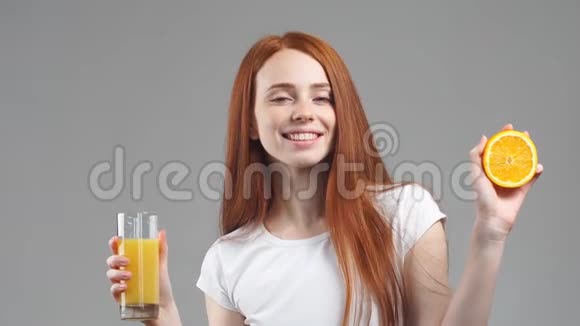 女孩拿着一杯橙汁对着镜头笑视频的预览图