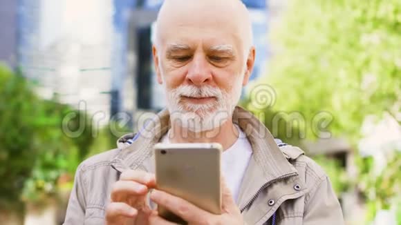 老人站在户外使用智能手机市中心商业区后台视频的预览图